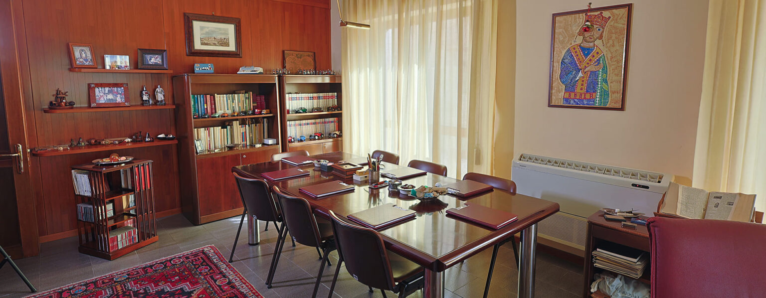 Interno di una sala riunioni con un tavolo elegante e sedie coordinate, con carpette sul tavolo Studio legale Gabriele Leone Palermo